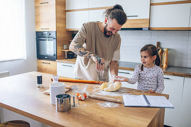 istock Happy father and daughter having fun while cooking pastry 2207492568