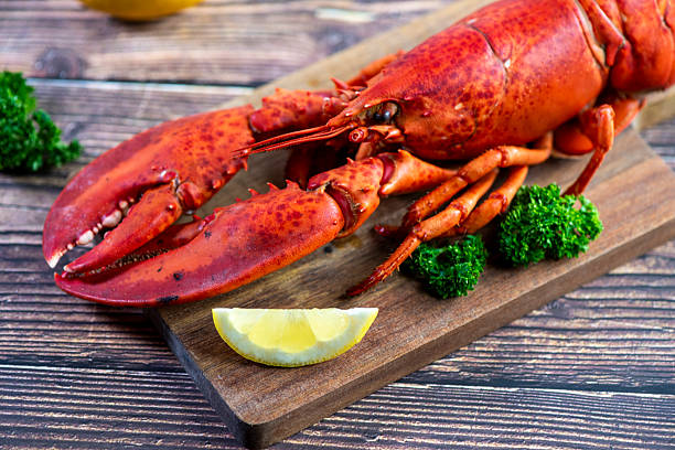 istock Red lobster on wooden cutting board 2207494503