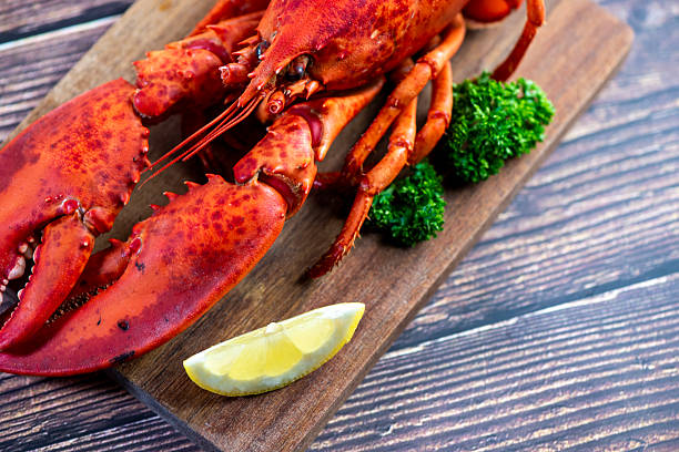 istock Red lobster on wooden cutting board 2207495381