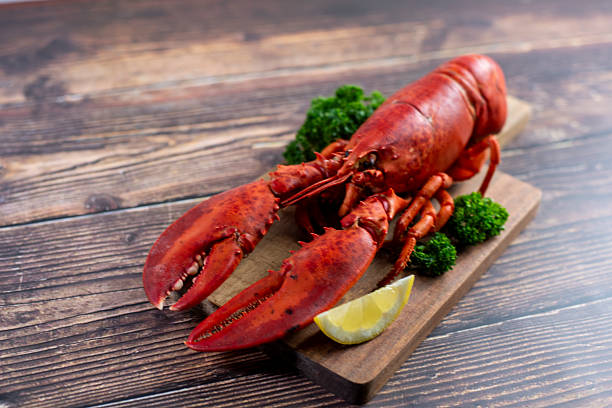 istock Red lobster on wooden cutting board 2207495581
