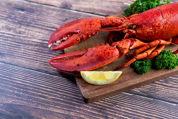 istock Red lobster on wooden cutting board 2207495582