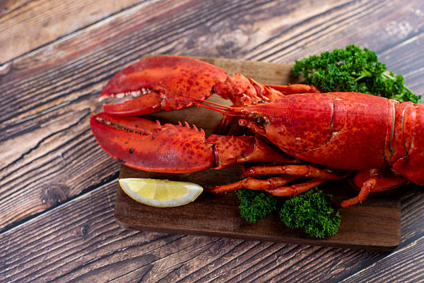 istock Red lobster on wooden cutting board 2207495617