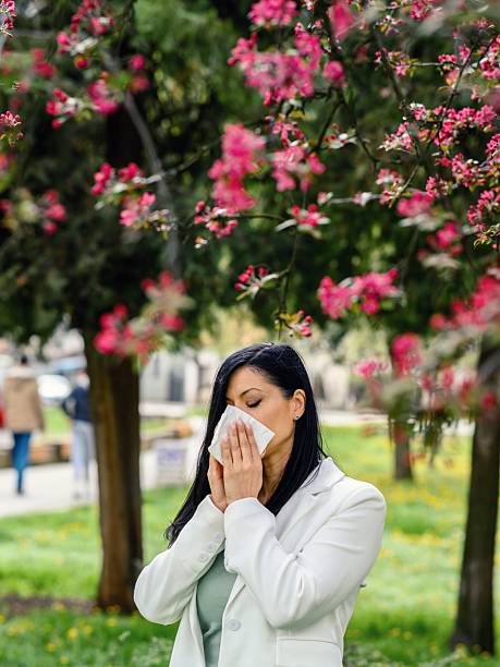 istock Woman sneezing in the blossoming garden 2207497749