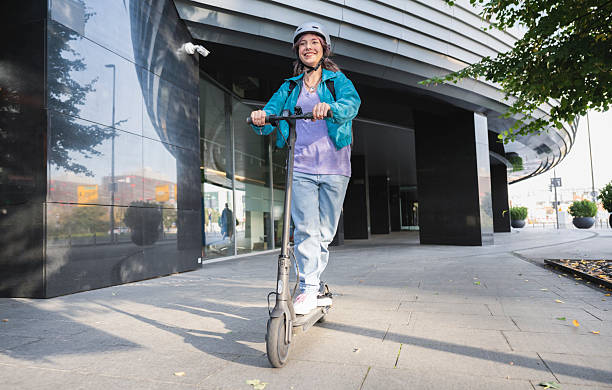 istock Woman Riding Her E-scooter On Sidewalk In City 2207499003
