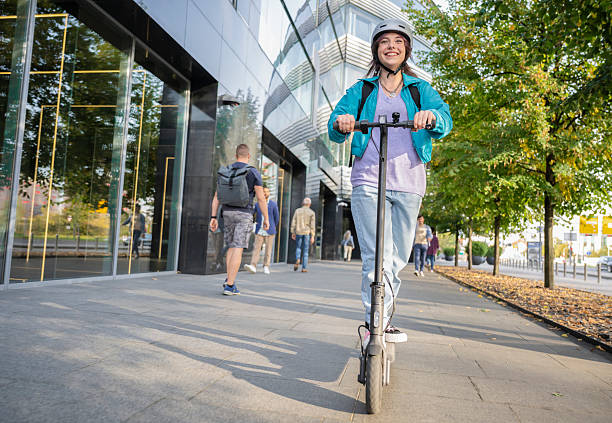 istock Woman Riding Her E-scooter On Sidewalk In City 2207499005