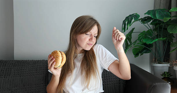 istock Person listening to music while eating burger, relaxed home setting, 2207508368