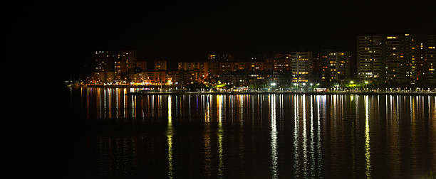 istock City lights reflecting on the sea at night 2207512735