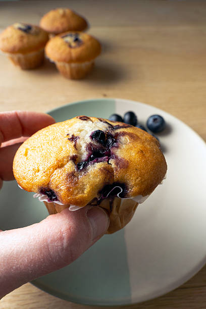 istock A person is holding a blueberry muffin 2207514284