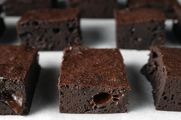 A close up of a chocolate brownie on white surface