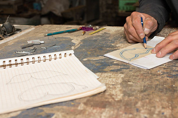 istock The Creative Process: Ironwork Artist Drawing Plans for Their Next Piece 2207518890