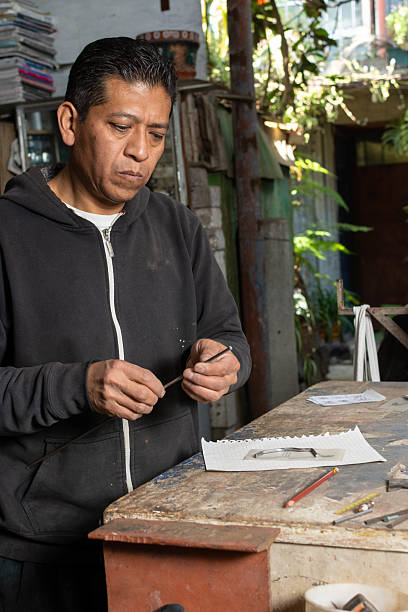 istock Sculpting with Care: Blacksmith Assessing Metal Rod for Artistic Transformation 2207518968