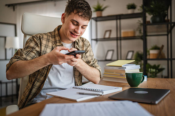 istock young man student take a photo of notes while study at home 2207525362