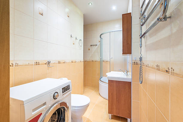 istock Modern Home Bathroom Interior With Shower, Washing Machine, and Tiled Walls 2207526444