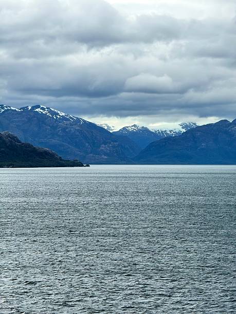 istock Snow-Capped Mountains and Deep Fjord Under Cloudy Sky in Remote Wilderness 2207526823