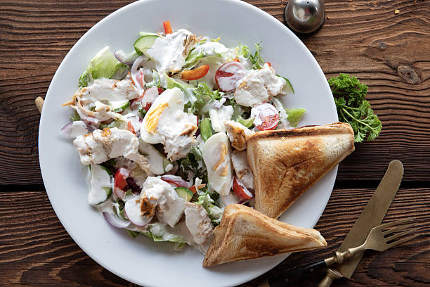 Tasty Egg salad with toast on wooden table.