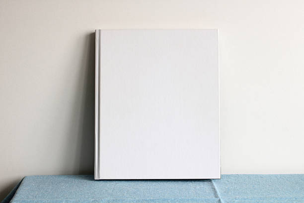 istock White blank book or album standing on blue tablecloth near white wall 2207530801