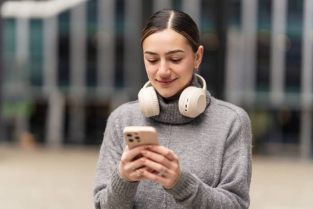 istock Work from anywhere, thrive everywhere. A remote freelancer in casual wear uses headphones and a phone to manage projects on the go, embracing the freedom of digital nomadism 2207538152