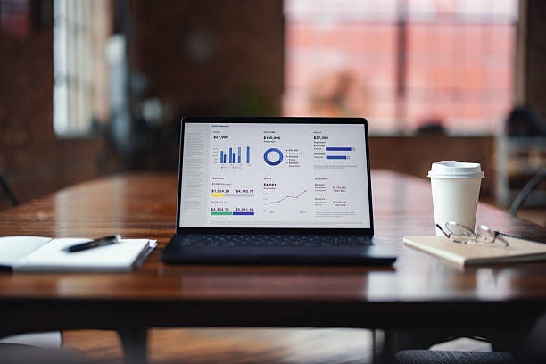 istock Laptop Displaying Business Analytics on Wooden Desk in Modern Office Workspace 2207541570