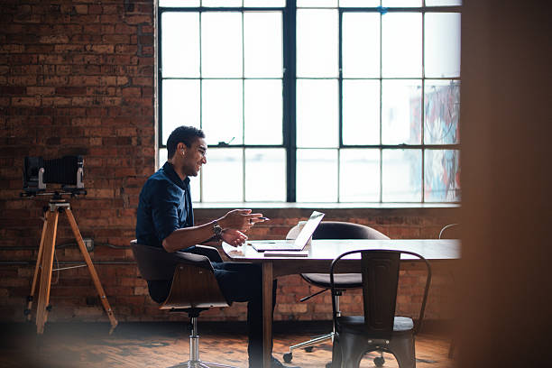 istock Professional Workspace Featuring a Brick Wall and Large Industrial Window 2207541593