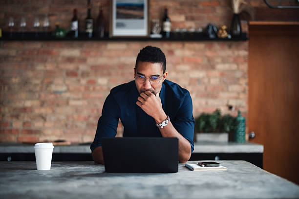 A person deeply engaged, working on a laptop with focus, set in a contemporary-style room with a cozy and modern ambiance. Perfect depiction of productivity and determination in an urban environment.