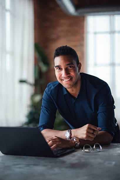 istock Smiling Entrepreneur Working on a Laptop in a Stylish Co-Working Space 2207541647