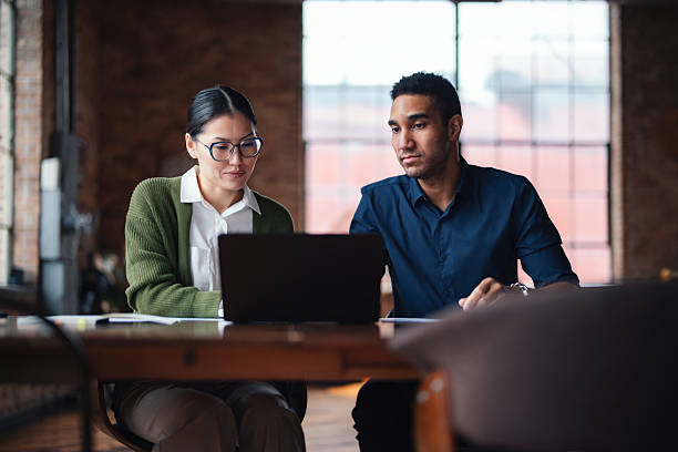istock Professionals Collaborating Together in a Modern Office Environment with Laptops 2207541655