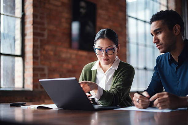 istock Colleagues Collaborating in a Modern Office Space with Natural Lighting 2207541660