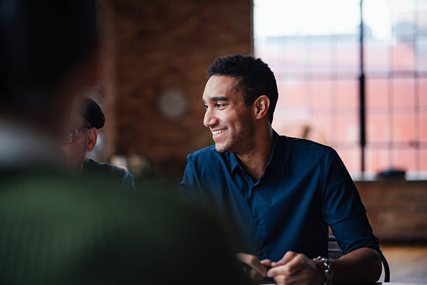 Professional Co-Working Space With Smiling Man at Group Business Meeting