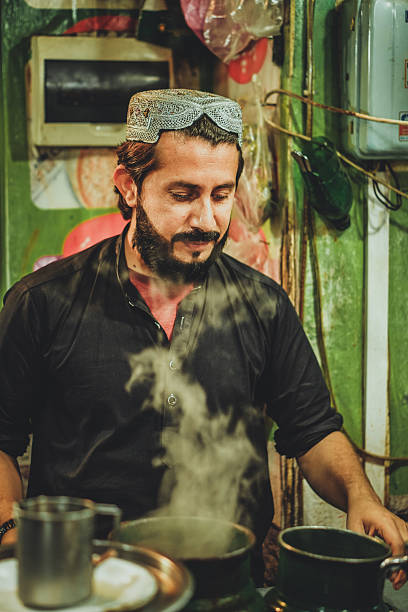 Young Pakistani Afghani Pathan man preparing chai tea in his roadside stall