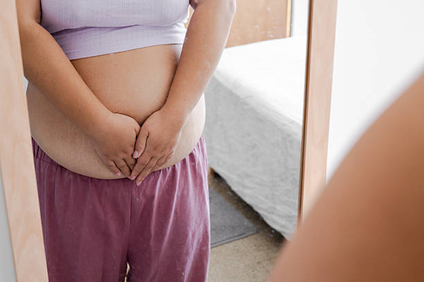 istock Realistic Plus-Size Woman Reflecting on Body Image in Home Setting. 2207553533