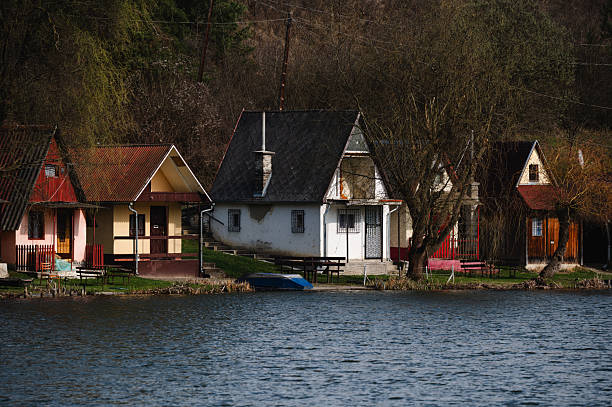 istock Lakeside cottages surrounded by forested hills 2207558245