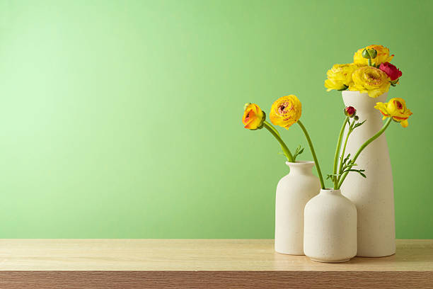 Spring and Easter concept with flowers in modern vase over green wall background. Interior mock up design for product display
