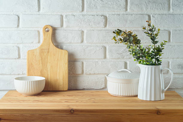 istock Kitchen table with kitchen utensils and plant over white brick wall  background.  Kitchen mock up for design and product display 2207563775