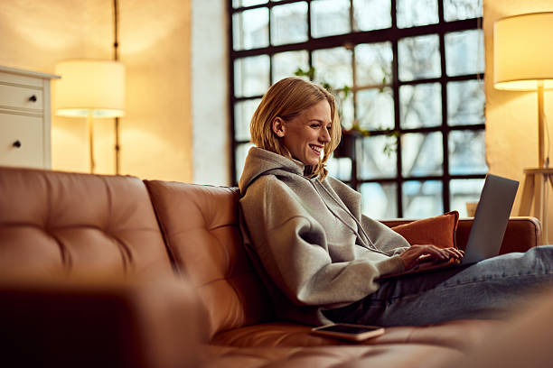 istock Young Woman Smiling While Using Laptop at Home in Cozy Environment 2207563814