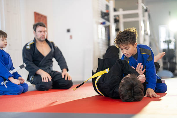 istock Young Boys Practicing Brazilian Jiu-Jitsu on a Mat Under Instructor Supervision 2207567052