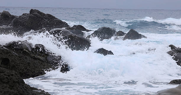 Very strong winds and waves crashing against the rocky shore
