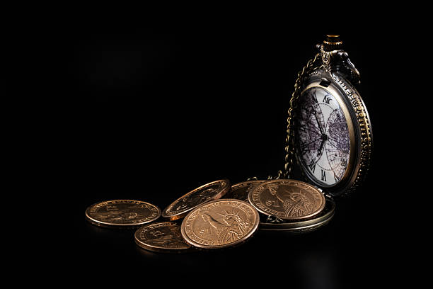 istock US $1 Coins and Pocket Watch on Black Background 2207577163