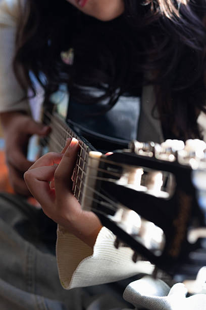 istock close frame of a woman practicing acoustic guitar 2207581574