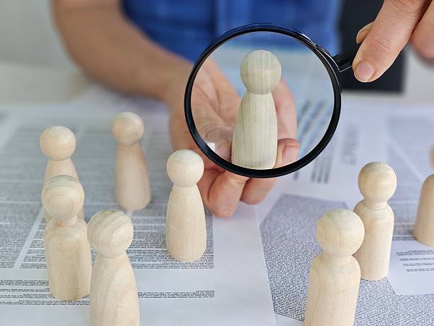 istock Analysis and evaluation with wooden figures under magnifying glass at workspace concept 2207583065