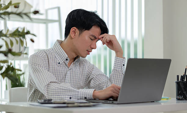 istock Tired businessman massaging nose bridge, fatigued from computer work. 2207589188