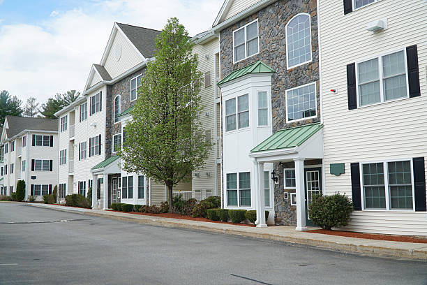 istock rental apartment buildings in a row with spring tree 2207590639