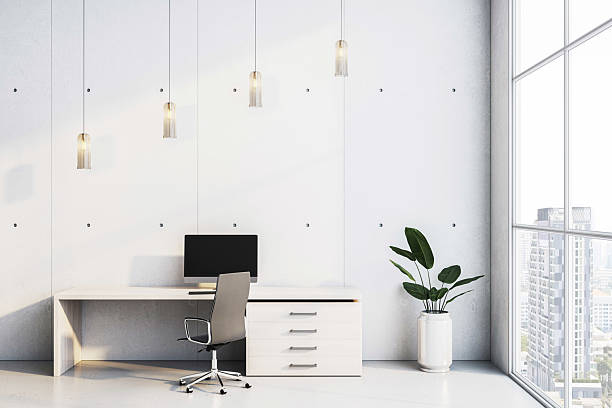 istock Modern minimalist office interior with white desk, computer, and chair near large window overlooking city buildings in bright daylight. 3D Rendering 2207592216