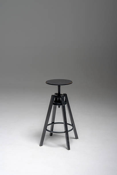 istock Black industrial-style stool on minimalist background 2207597973