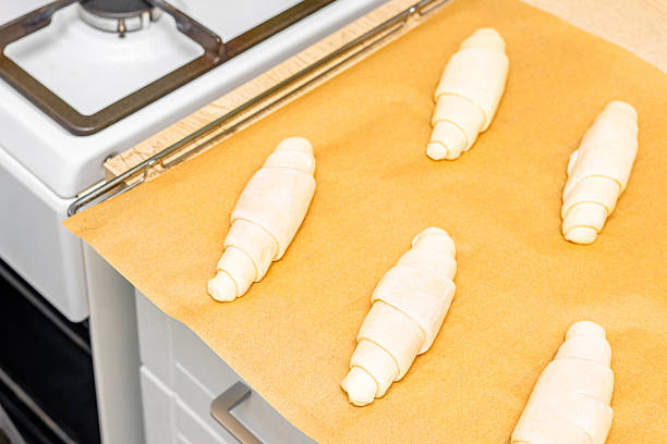 a tray of croissants in a home kitchen. making croissants at home. homemade baked goods. unbaked croissant. uncooked croissant.