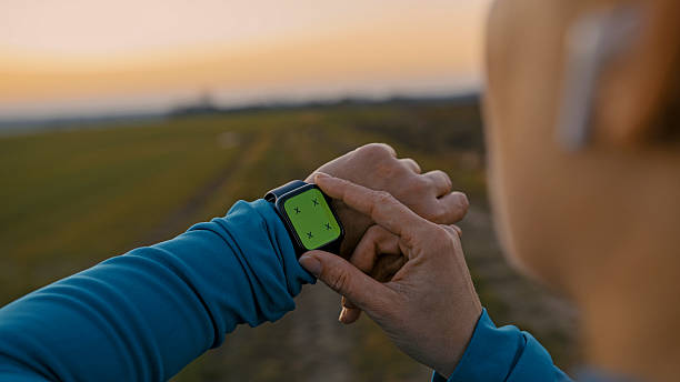 istock Woman Adjusts Smartwatch in Autumn Outdoors at Sunset 2207603175