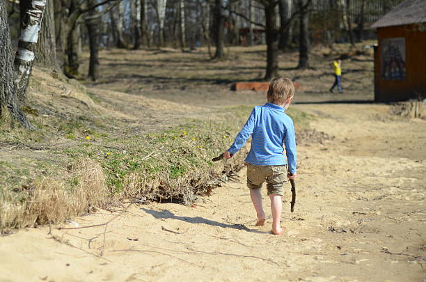 istock Young Boy Playing with Sticks in the Park 2207605811