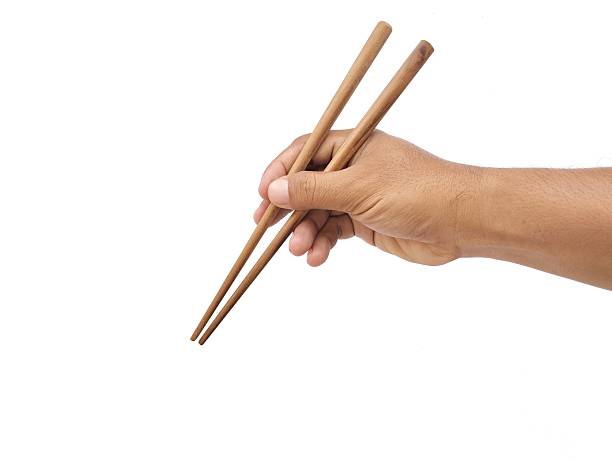 istock Man hand holding chopsticks isolated on white background 2207611787