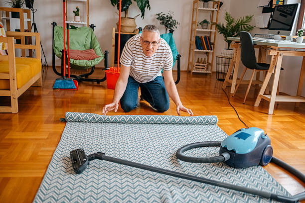 istock Mid adult man cleaning his home using vacuum cleaner 2207612111
