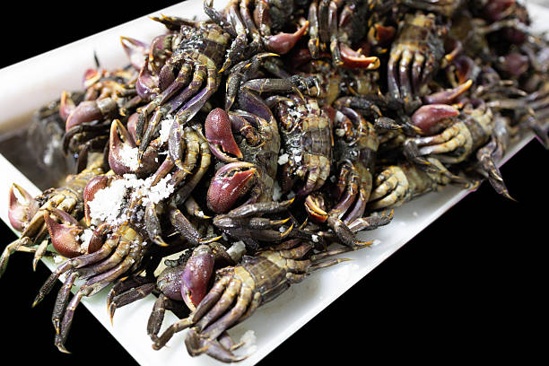 Marinated ricefield crab with salted for sale at the seafood market, on black isolated.