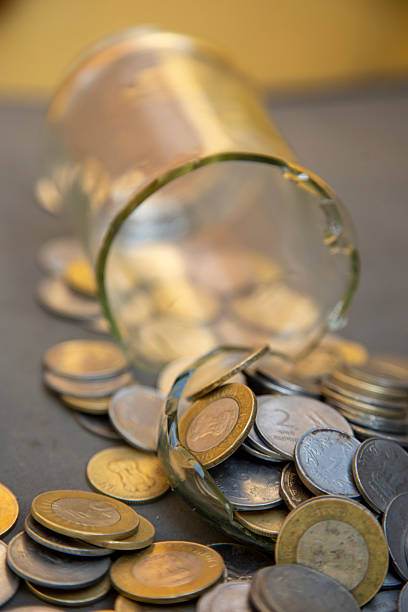istock Broken Glass Jar with Scattered Indian Currency Coins Symbolizing Financial Instability 2207612991